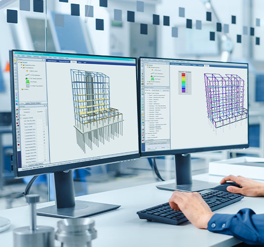 An engineer works on a computer to code check a building.
