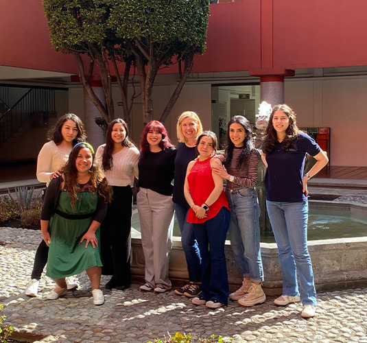 A group of Altair's Staffing Services team standing outdoors in an office building courtyard located in Mexico.